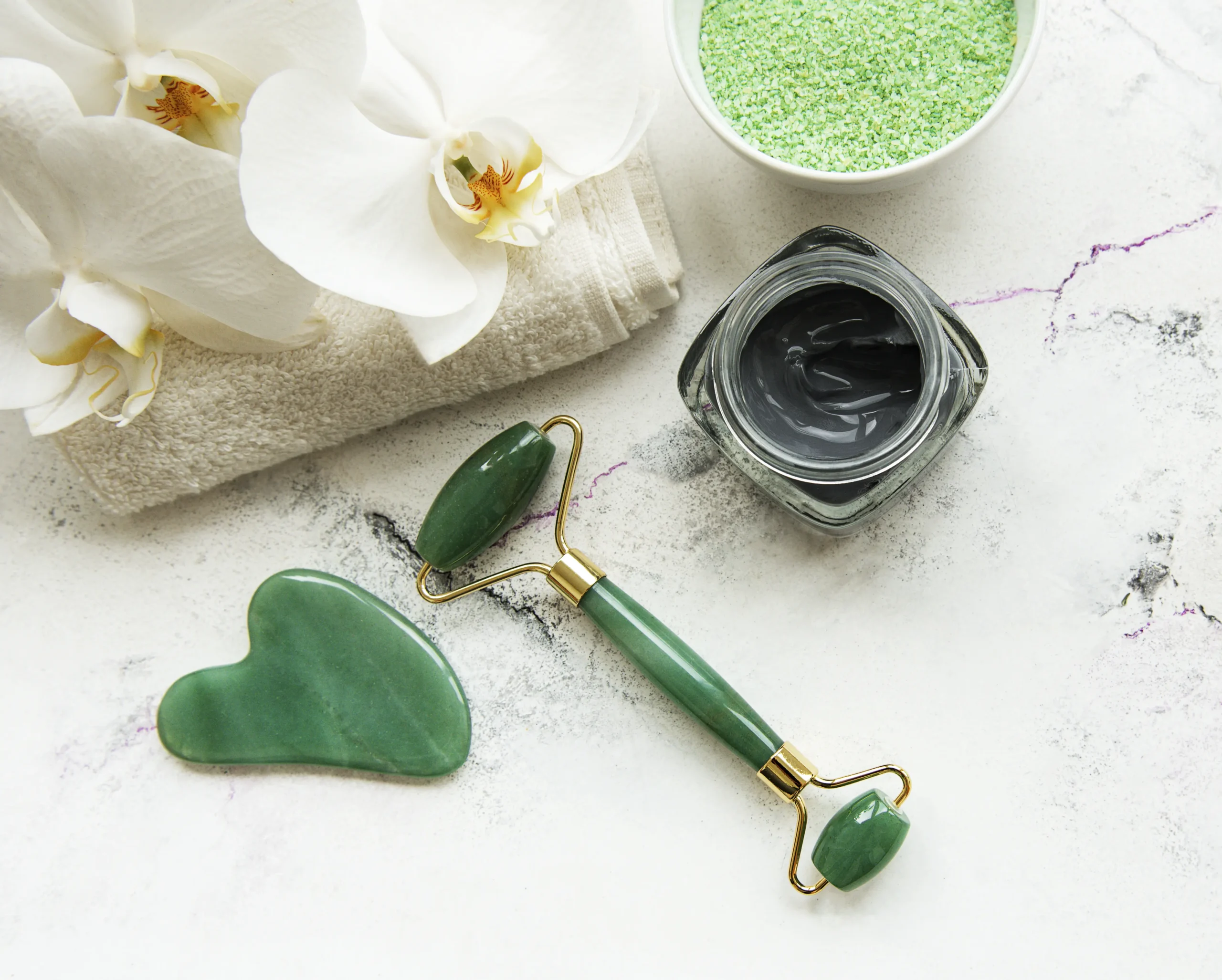 Jade gua sha stone and facial roller used in our gua sha treatment